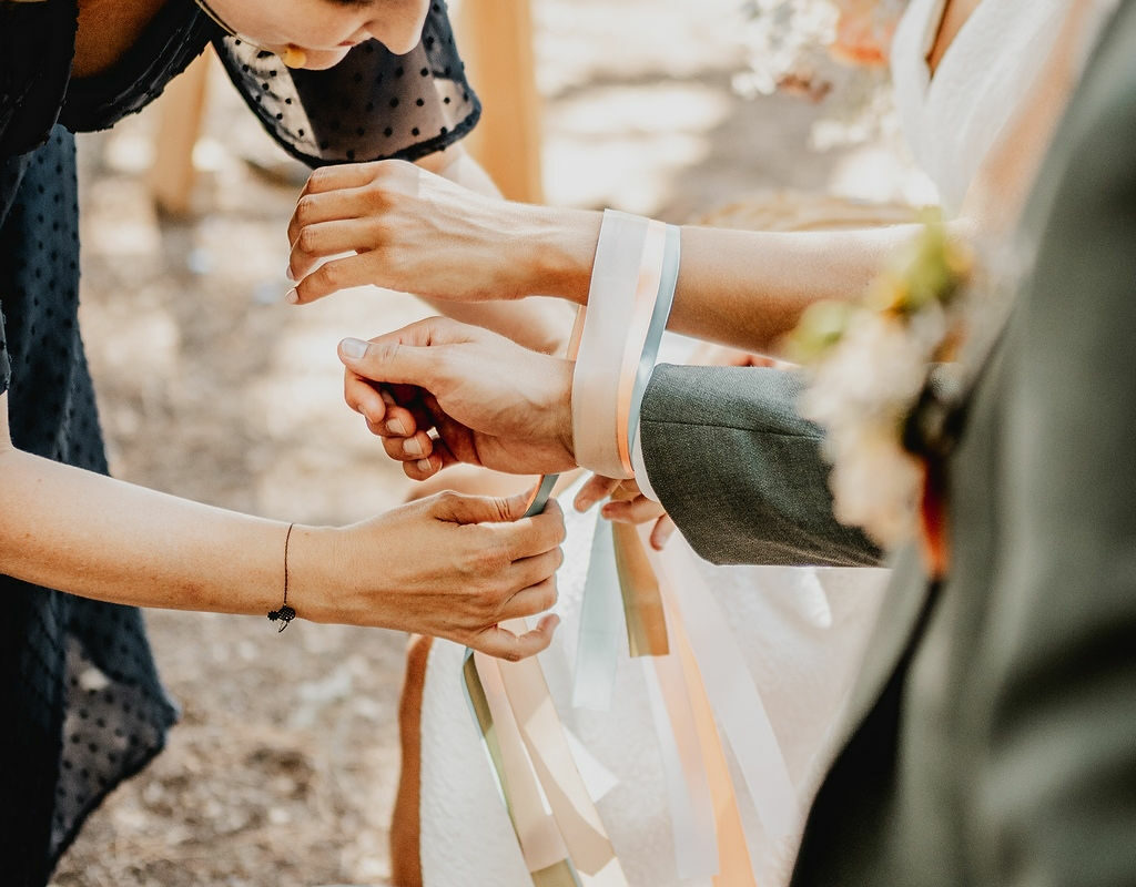 Aude, officiante de cérémonie laïque, en pleine célébration d'un mariage à Toulouse en Occitanie lors du rituel des rubans