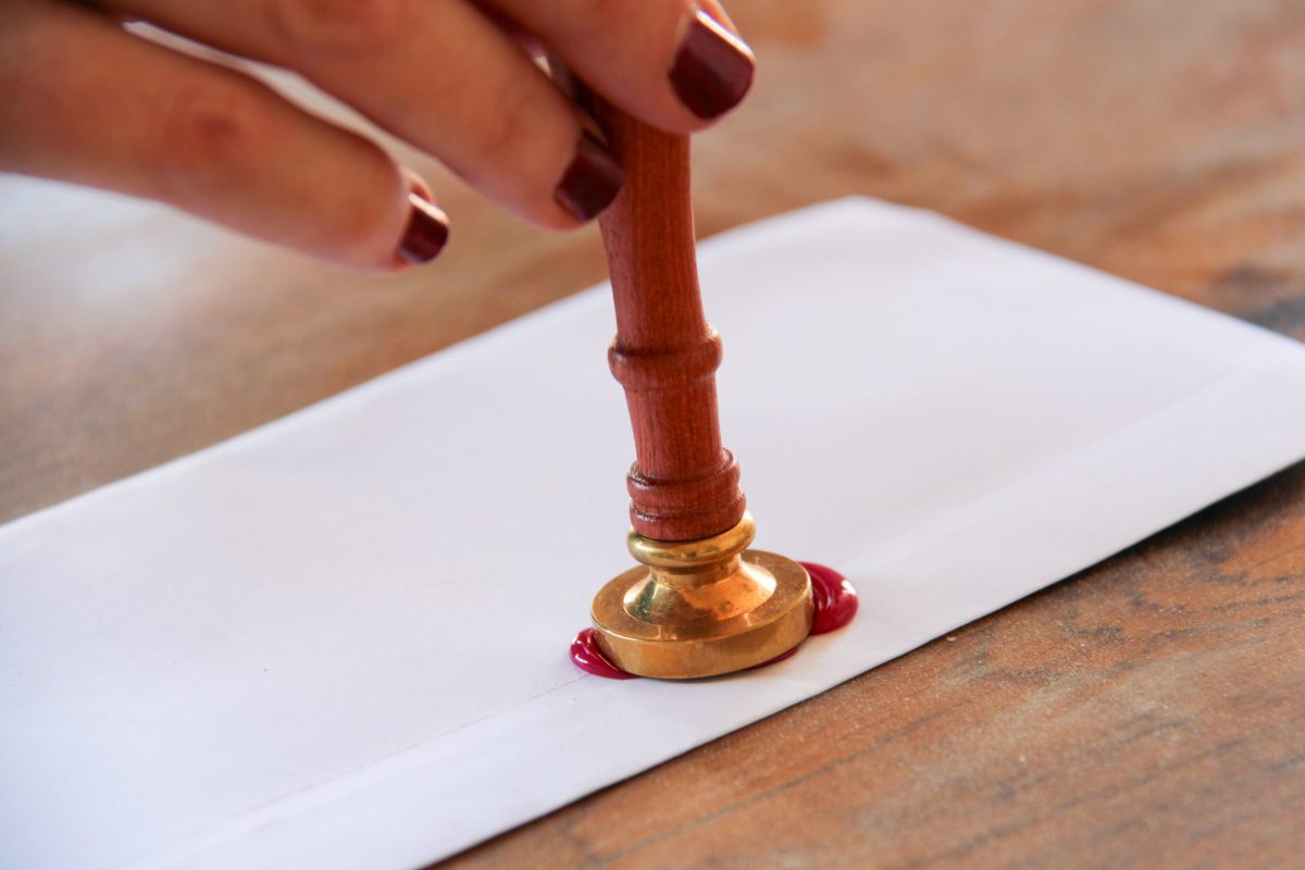 Focus sur une main d'un couple heureux lors d'une cérémonie laïque, à Toulouse en Occitanie lors du rituel du cachet de cire et de la lettre d'amour scellée